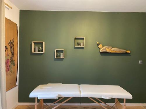 una pared verde con un banco blanco en una habitación en Gîte privé avec sauna et balnéo, en Brens