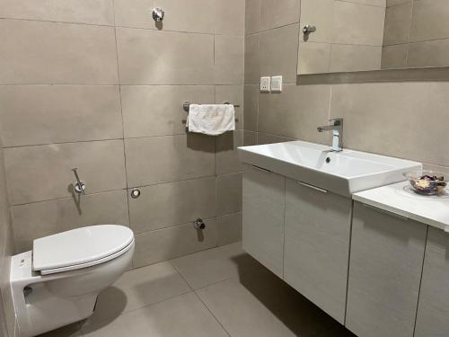 a bathroom with a toilet and a sink at Queens View Apartment in Accra