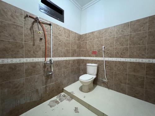 a bathroom with a shower and a toilet in it at OYO 92098 Kost Orange Syariah in Gusung