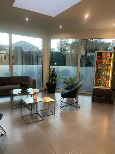 a living room with a couch and a table and chairs at Kyriad Saint Fargeau Ponthierry - Apollonia in Saint-Fargeau-Ponthierry