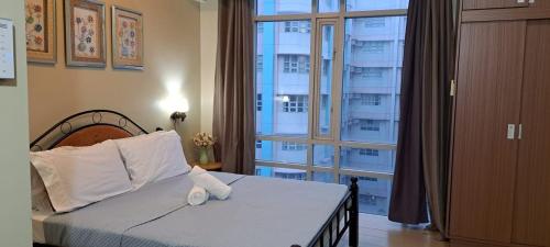 - une chambre avec un lit et une grande fenêtre dans l'établissement Condo Deluxe near NAIA Terminal 3, à Manille