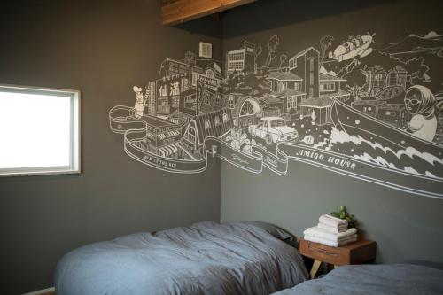 a bedroom with a mural of a city on the wall at AMIGO HOUSE in Zushi
