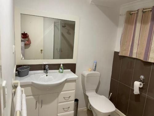 a bathroom with a sink and a toilet and a mirror at OCEAN GET AWAY in Rye