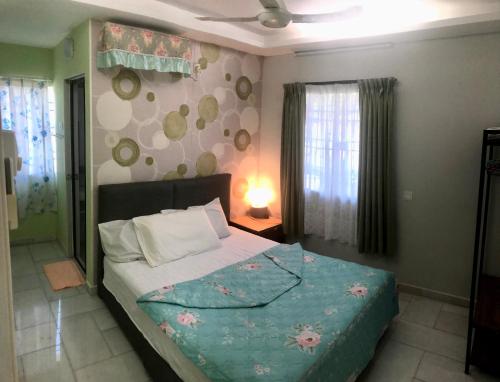 1 dormitorio con 1 cama con edredón azul en Ipoh Tambun Cozy & comfortable, en Kampong Batu Lapan