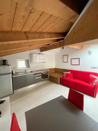 a living room with a red couch and a kitchen at La Casa di Giò in Arco