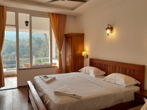 a bedroom with a large bed with a large window at Green Valley Vista in Munnar