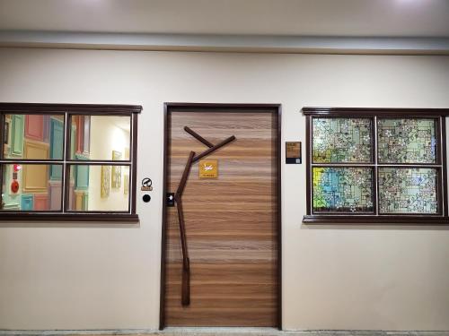 une porte en bois avec deux fenêtres sur un bâtiment dans l'établissement 小窩旅店-礁溪溫泉店, à Jiaoxi