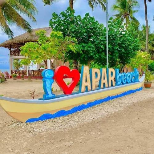 a boat on the beach with a sign that says apar beach at Apar Beach Resort in Mataba