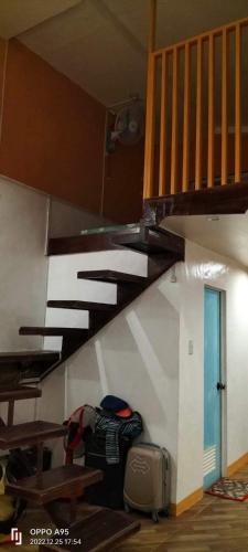 a staircase in a room with a table and a stair case at Apar Beach Resort in Mataba