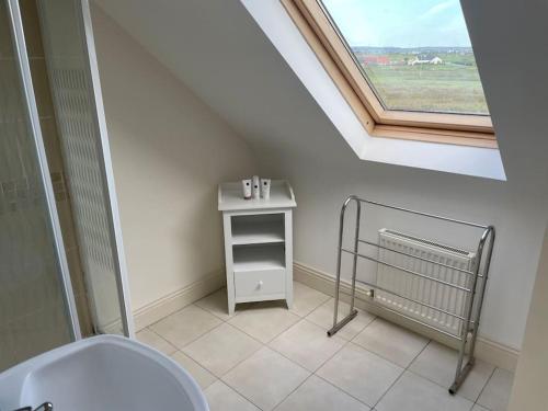 uma casa de banho com um WC branco e uma janela em Modern 5 bedroom house in Spanish Point Clare em Spanish Point