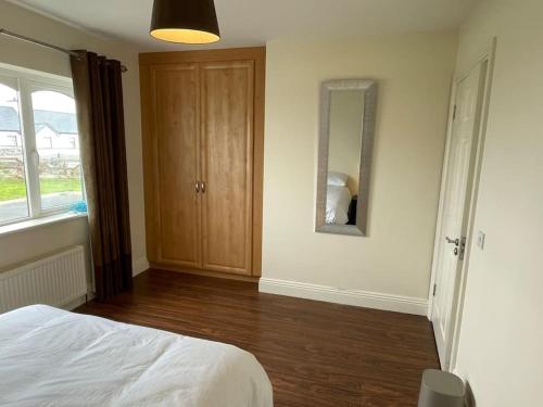 a bedroom with a bed and a mirror on the wall at Modern 5 bedroom house in Spanish Point Clare in Spanish Point
