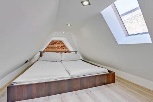 a bed in a room with a brick wall at Hello Apartments Sw Ducha Loft for 4 guests in Gdańsk
