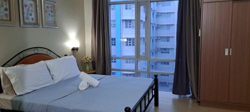 1 dormitorio con cama y ventana grande en Lovely condo near NAIA terminal 3, en Manila