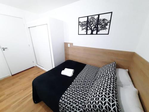 1 dormitorio con 1 cama con edredón blanco y negro en Studio próximo Avenida Paulista - Bela 02, en São Paulo