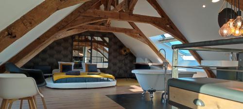 a bedroom with a bed in a room with wooden beams at Apparthotel loft Martigné-Ferchaud in Martigné-Ferchaud
