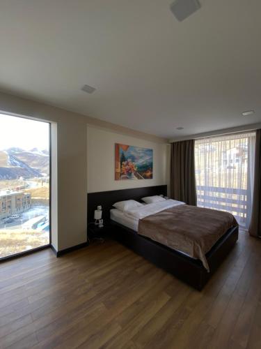 a bedroom with a large bed and a large window at Gudauri Diamond in Gudauri