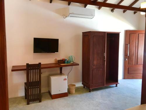 a room with a desk and a tv on a wall at Bali Villa Mirissa in Mirissa