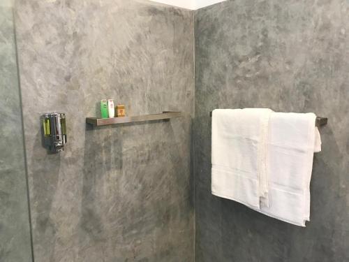 y baño con ducha y toallas blancas. en Bali Villa Mirissa, en Mirissa