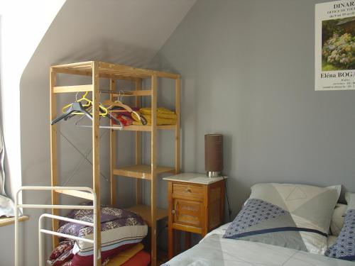 a room with a bed and a wooden shelf next to a bedroom at GUERINEL HERBERT PIERRETTE in Hirel