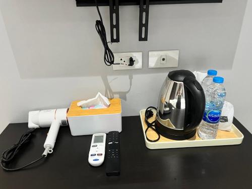 a black counter top with a coffee maker and water bottles at Aowmana Hotel in Makkasan