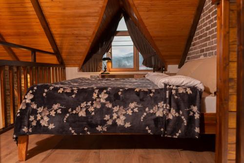 Schlafzimmer mit einem schwarzen und weißen Bett und einem Fenster in der Unterkunft Abant Cozy Homes in Bolu