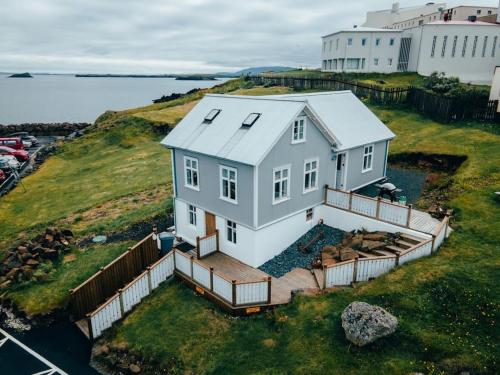 a white house on a hill with a deck at Tanginn in Stykkishólmur