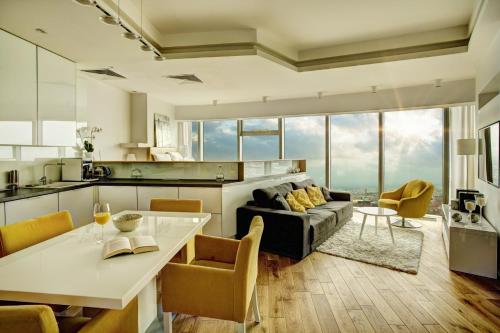 uma cozinha e sala de estar com um sofá e uma mesa em Apartamenty Sky Tower em Breslávia