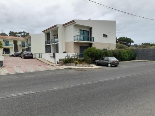 un edificio bianco con auto parcheggiate in un parcheggio di Vilas Horizonte a Porto Santo