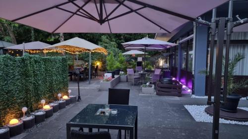 a patio with tables and umbrellas and a restaurant at Niederdreisbacher Hof in Niederdreisbach
