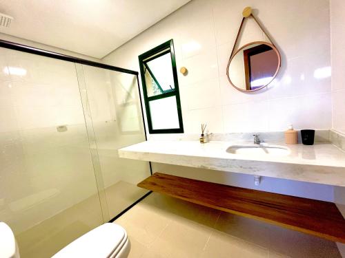 ein Badezimmer mit Waschbecken, Spiegel und Toilette in der Unterkunft Delícia de casa em Barra do Una a 5 min de Juquehy! in São Sebastião