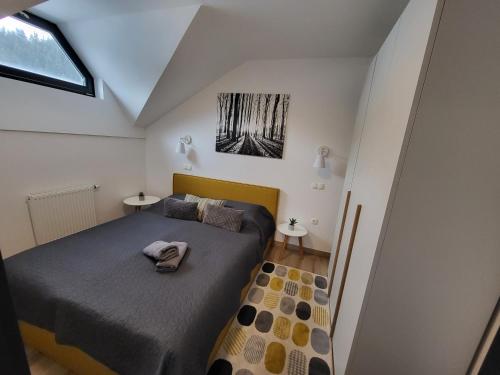 1 dormitorio pequeño con 1 cama y 2 mesas en Apartma A1 GOLTE, en Mozirska Koča