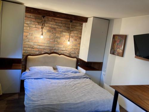 a bed in a room with a brick wall at Little L Apartments Dorćol in Belgrade