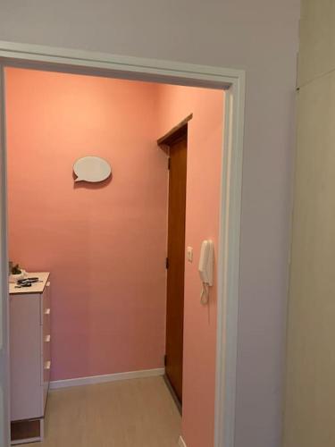 La salle de bains est pourvue d'un mur orange et d'une porte. dans l'établissement Charmant studio Ax les thermes, à Ax-les-Thermes