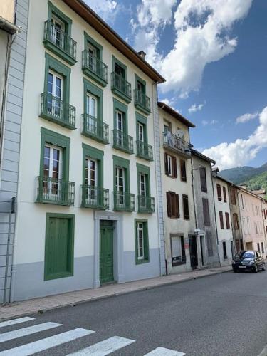 - un bâtiment avec des portes et des balcons verts dans une rue dans l'établissement Charmant studio Ax les thermes, à Ax-les-Thermes