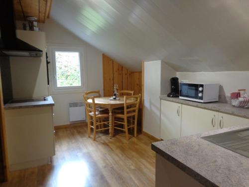 une cuisine avec une table et des chaises dans une pièce dans l'établissement Chez Corine Marque Badet, à Luz-Saint-Sauveur