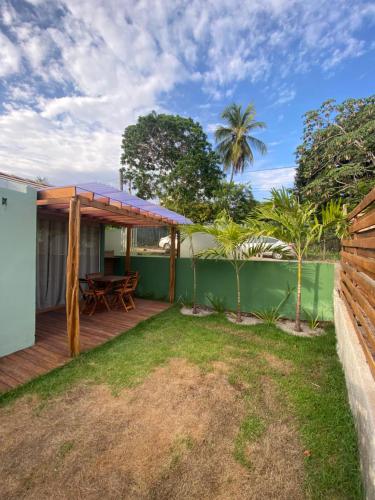 a backyard with a wooden deck with a table at Suítes Naldiane in Imbassai