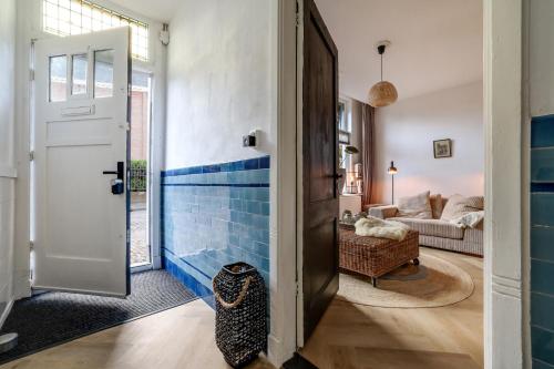 un pasillo con azulejos azules en las paredes y una puerta en Knus appartement in sneek, en Sneek