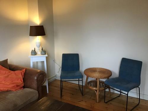 a living room with two chairs and a table and a couch at Countryhouse Zuid-Limburg in Nuth