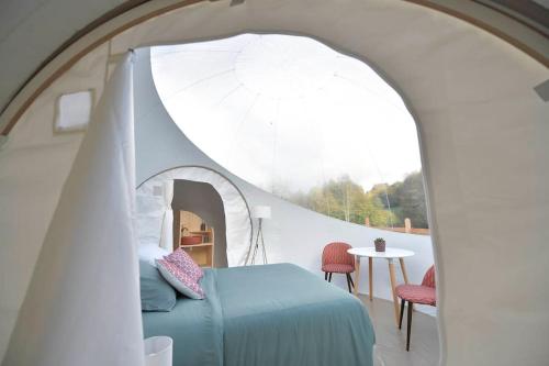 a bedroom with a blue bed and an archway at Bulle Hirondelle in Quarré-les-Tombes