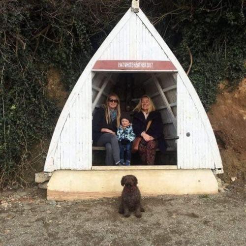 two women and a child sitting in a dog house at Alderberry Lodge in Newquay