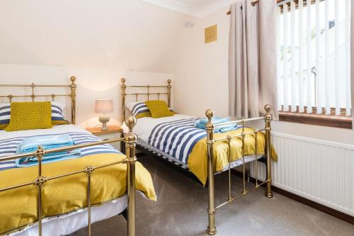 2 camas en un dormitorio con ventana en No27 Willowbank, en Dunkeld