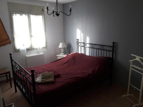 une chambre avec un lit avec une couverture rouge dans l'établissement Gambetta, à Pont-Saint-Esprit