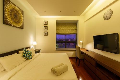 a bedroom with a bed and a desk and a television at Carlsen Residence in Colombo