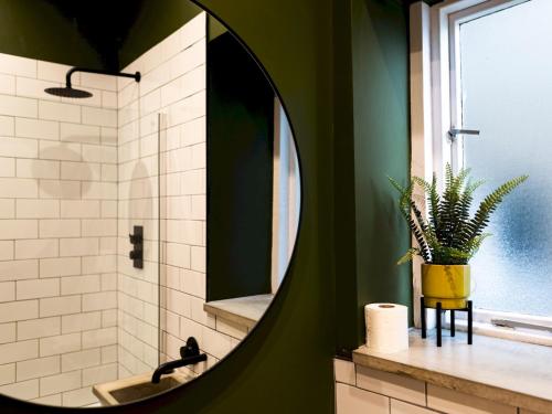 uma casa de banho com um espelho redondo e um lavatório em Pass the Keys Stylish cosy 2bed near Finsbury Park w balcony em Londres