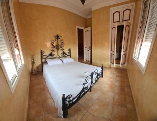 een slaapkamer met een wit bed in een kamer met ramen bij Appartement te huur in Marrakech in Marrakesh