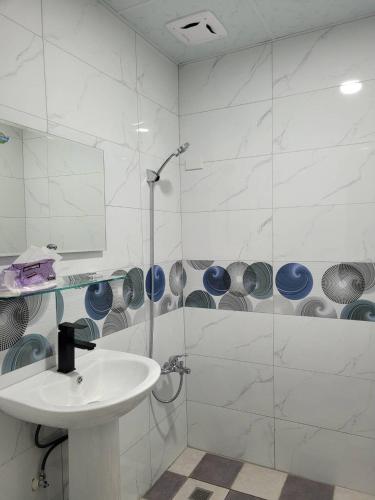 Un baño blanco con lavabo y ducha. en Flower B&B, en Hualien City