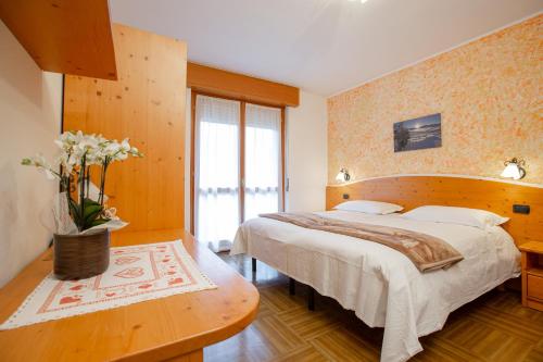 a bedroom with a bed and a vase of flowers at Hotel Biancospino in Lanzada