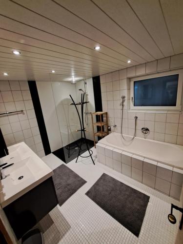 a large bathroom with a tub and a tv in it at ISIS---Ferienwohnung in Steinach am Brenner