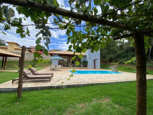 a backyard with a swimming pool and a house at Casa Jatobá da Serra in Serra do Cipo