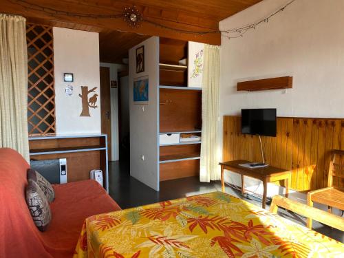 Un dormitorio con una cama, un televisor y una mesa. en Duplex Superbe Vue Montagne, en La Bourboule